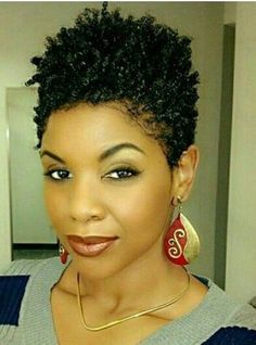 Here's a concise alt tag for the image: Woman with short, curly natural hairstyle.