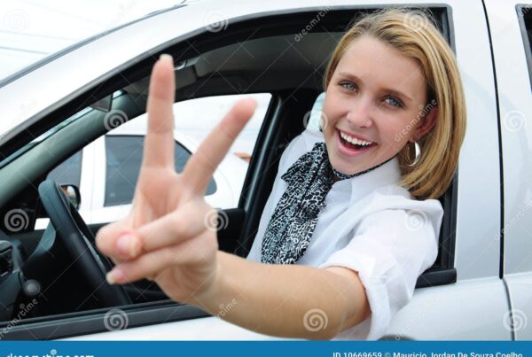 Happy woman in car, peace sign.